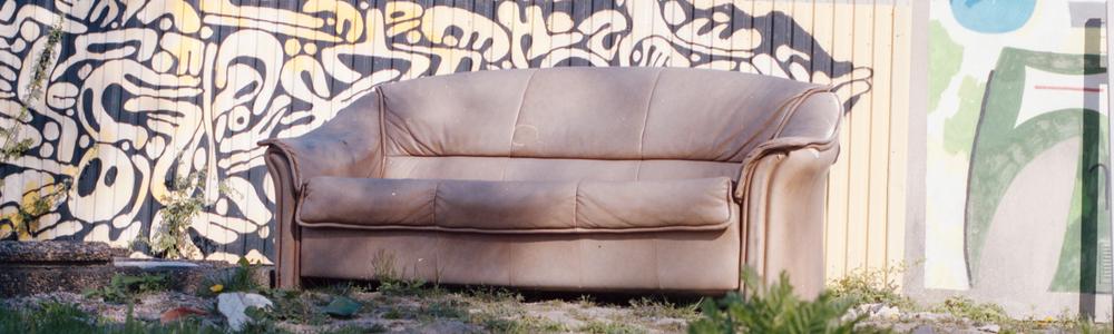 En brun soffa framför en vägg utomhus
